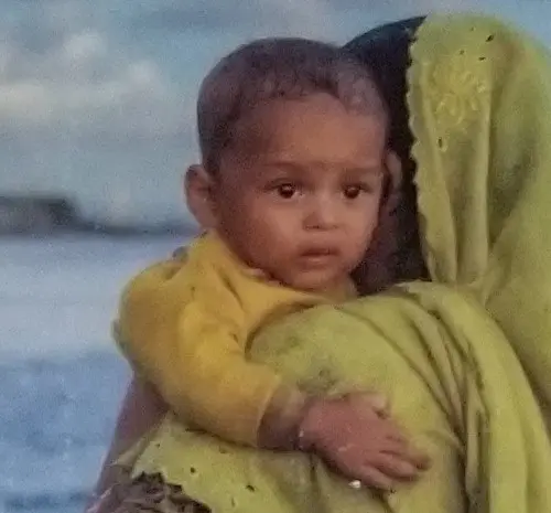 A woman holding a baby in her arms.